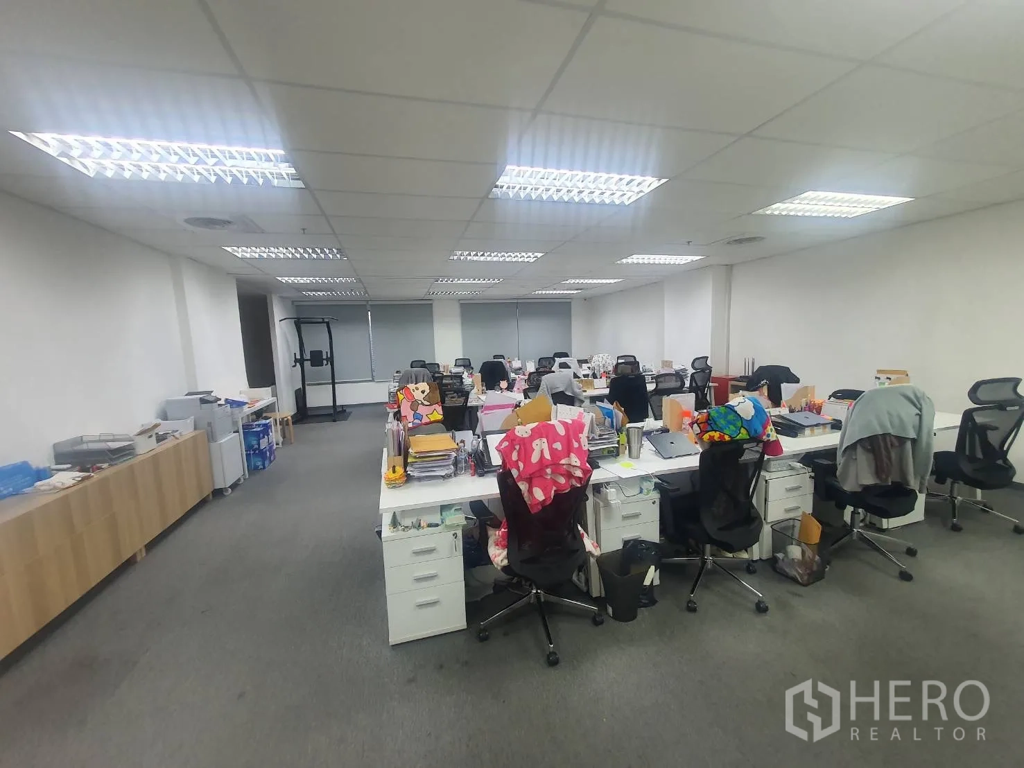 办公室 for rent in Watthana, Bangkok - 宽敞开放式办公区，成排工位与座椅，地毯地面与明亮顶灯。