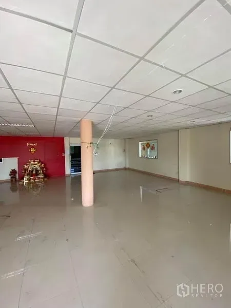 工厂 出租在Samut Sakhon - 宽敞办公区，吊顶与亮面地砖，尽头为红色特色墙面。