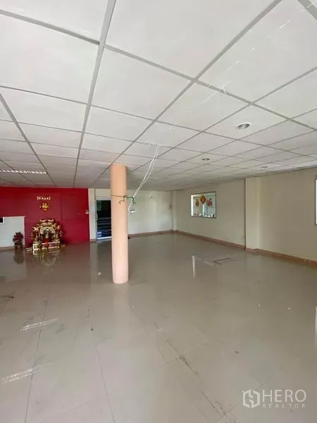 工厂 出租在Samut Sakhon - 宽敞办公区，吊顶与亮面地砖，尽头为红色特色墙面。