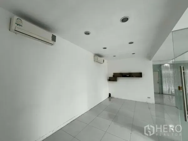 展厅 出租 - 空调办公室，白色瓷砖地面与壁挂置物架。