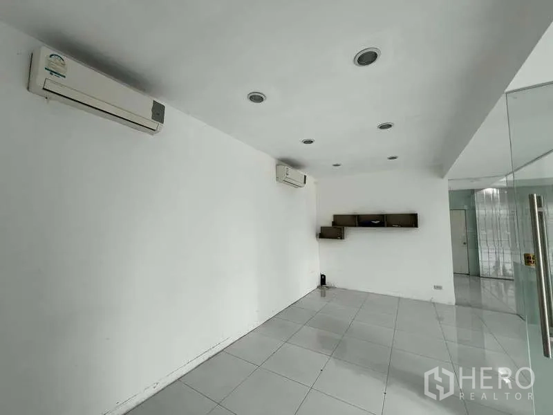 展厅 出租 - 空调办公室，白色瓷砖地面与壁挂置物架。