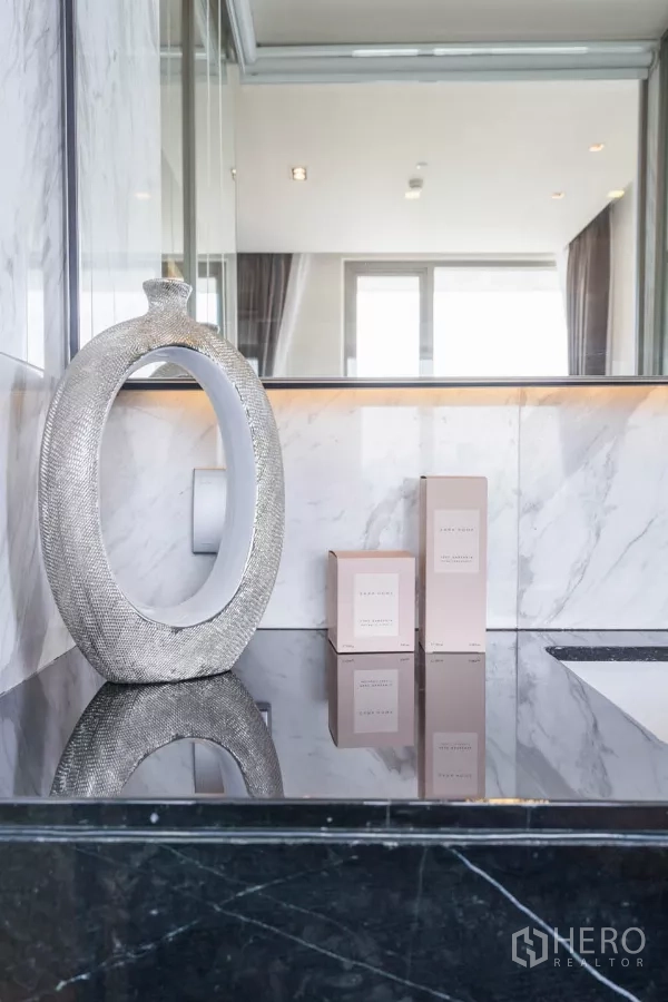 公寓 出租或出售在Bang Rak, Bangkok - 黑色大理石台面上的装饰摆件与柔和灯光。