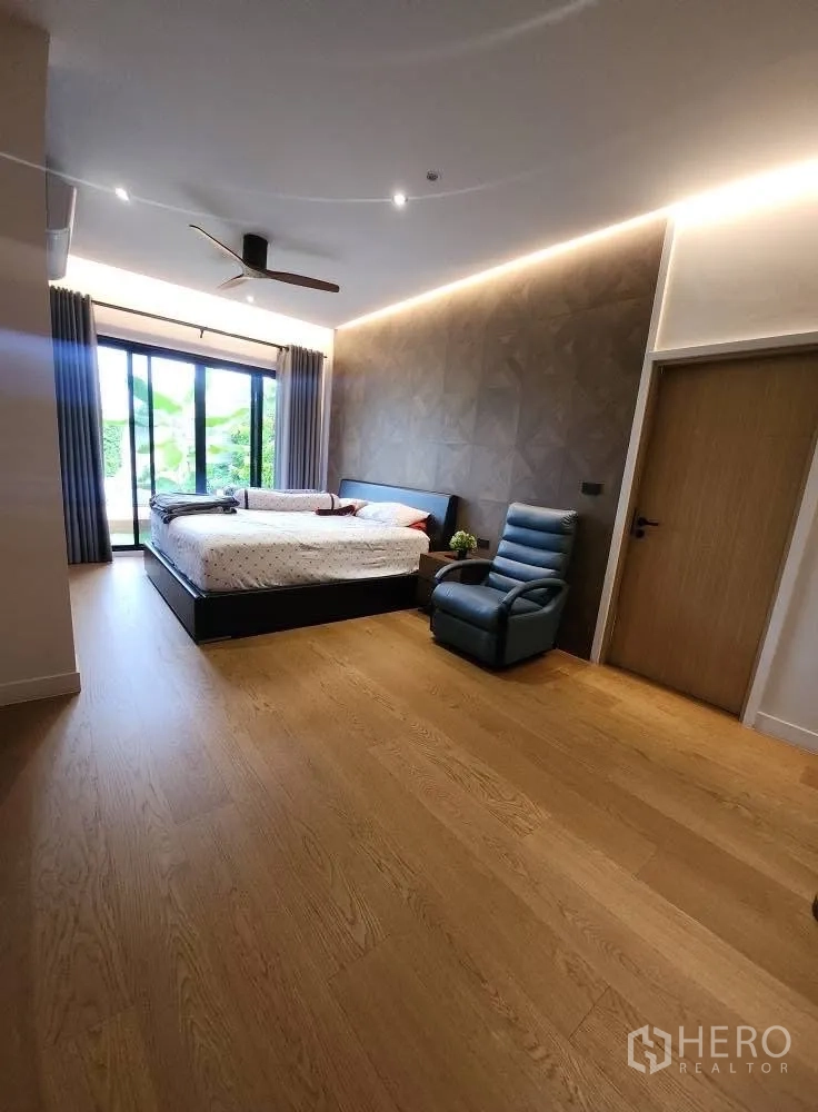 Detached House for rent in Bang Phli, Samut Prakan - Ground-floor bedroom with garden view, sliding doors and a seating area.