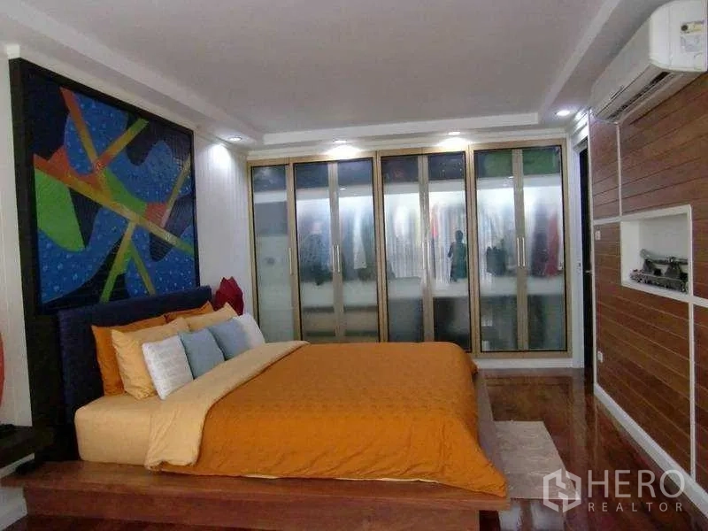 คอนโด ให้เช่าหรือขายในWatthana, Bangkok - ห้องนอนหลักเตียงแพลตฟอร์ม งานศิลป์ผนัง และตู้เสื้อผ้าบานกระจกฝ้ายาวเต็มผนัง