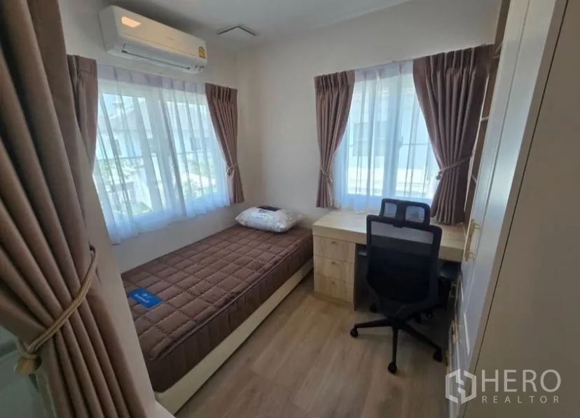 Detached House for rent in Bang Phli, Samut Prakan - Bright single bedroom with window drapes, study desk and air conditioner in a Bang Phli rental house.
