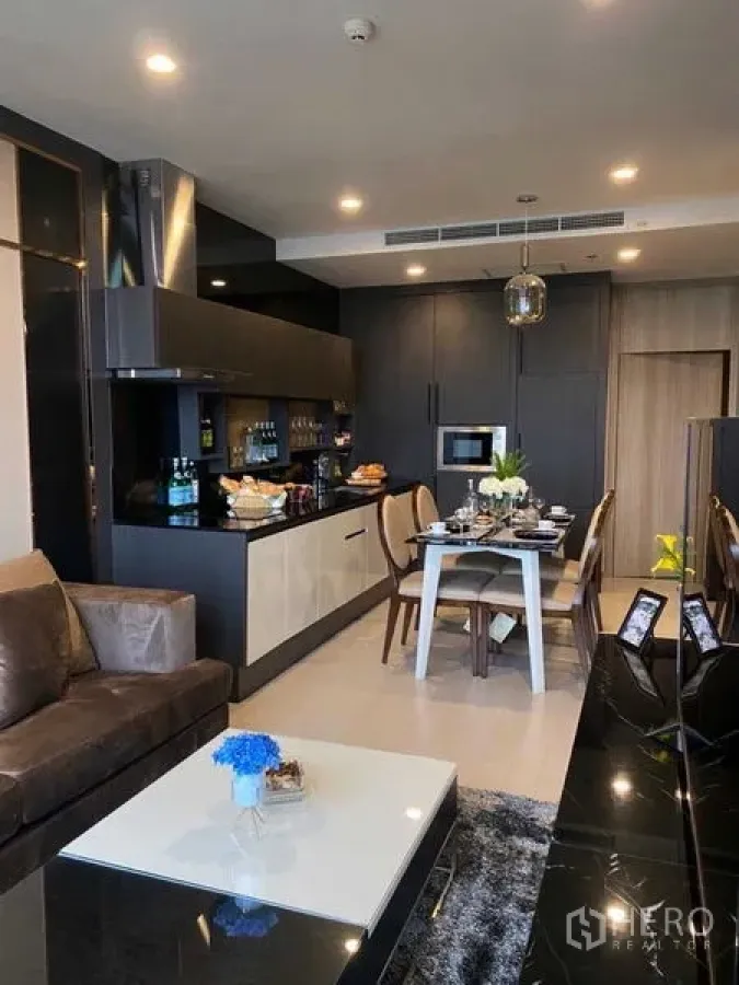 Condominium for sale in Pathum Wan, Bangkok - Contemporary kitchen with built-in appliances and a four-seat dining table.