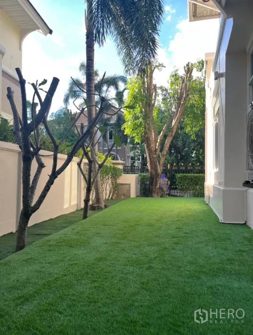 独立式住宅 出租或出售在Lat Phrao, Bangkok - 侧院草坪，棕榈树与屋侧空间。