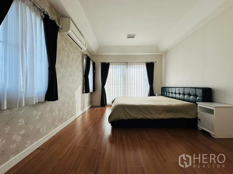 Detached House for sale in Prawet, Bangkok - Spacious master bedroom with wood flooring, large windows and a double bed.
