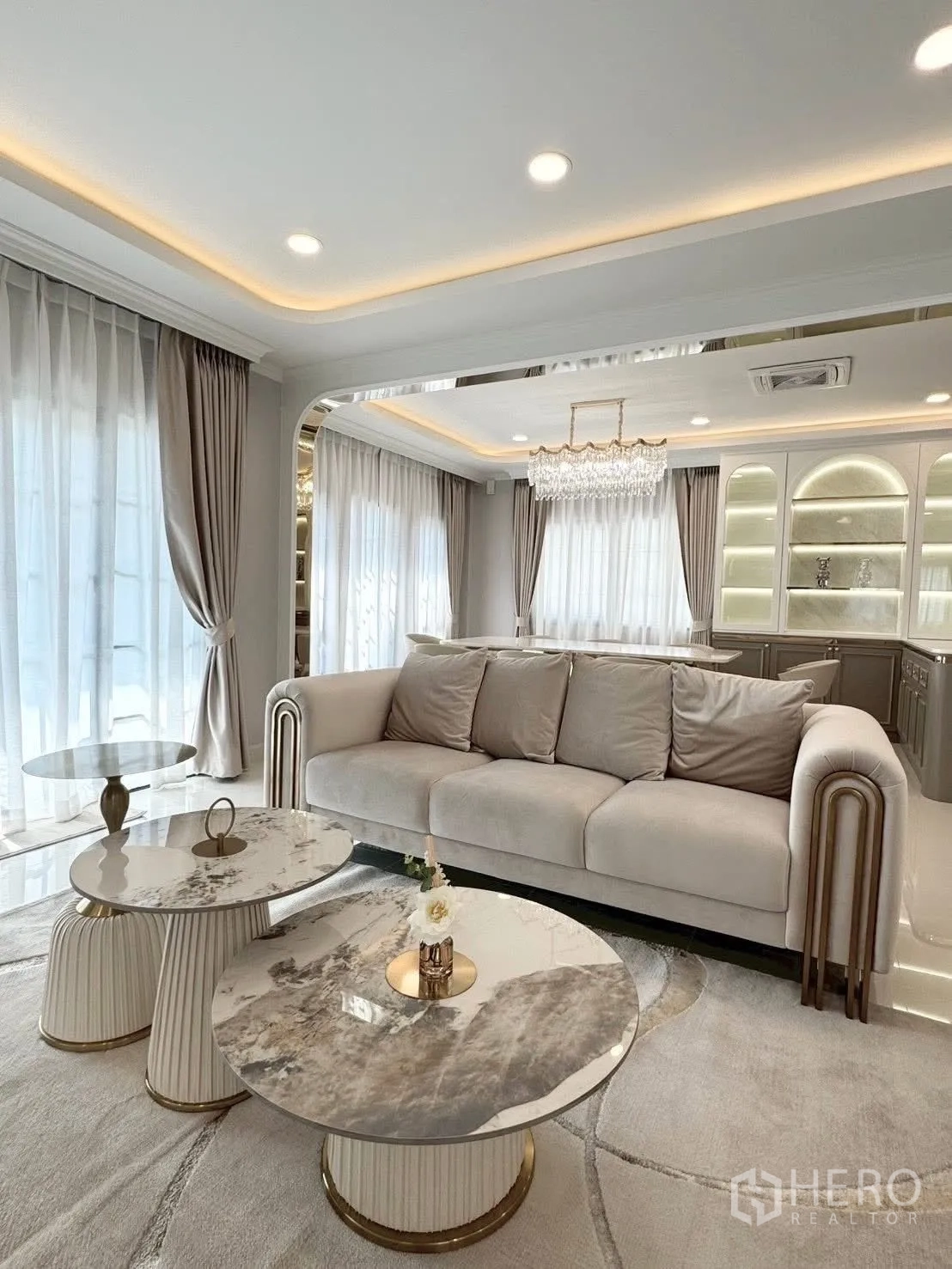 Detached House for rent in Bang Phli, Samut Prakan - Elegant living room with beige sofa and marble coffee tables under recessed lighting.