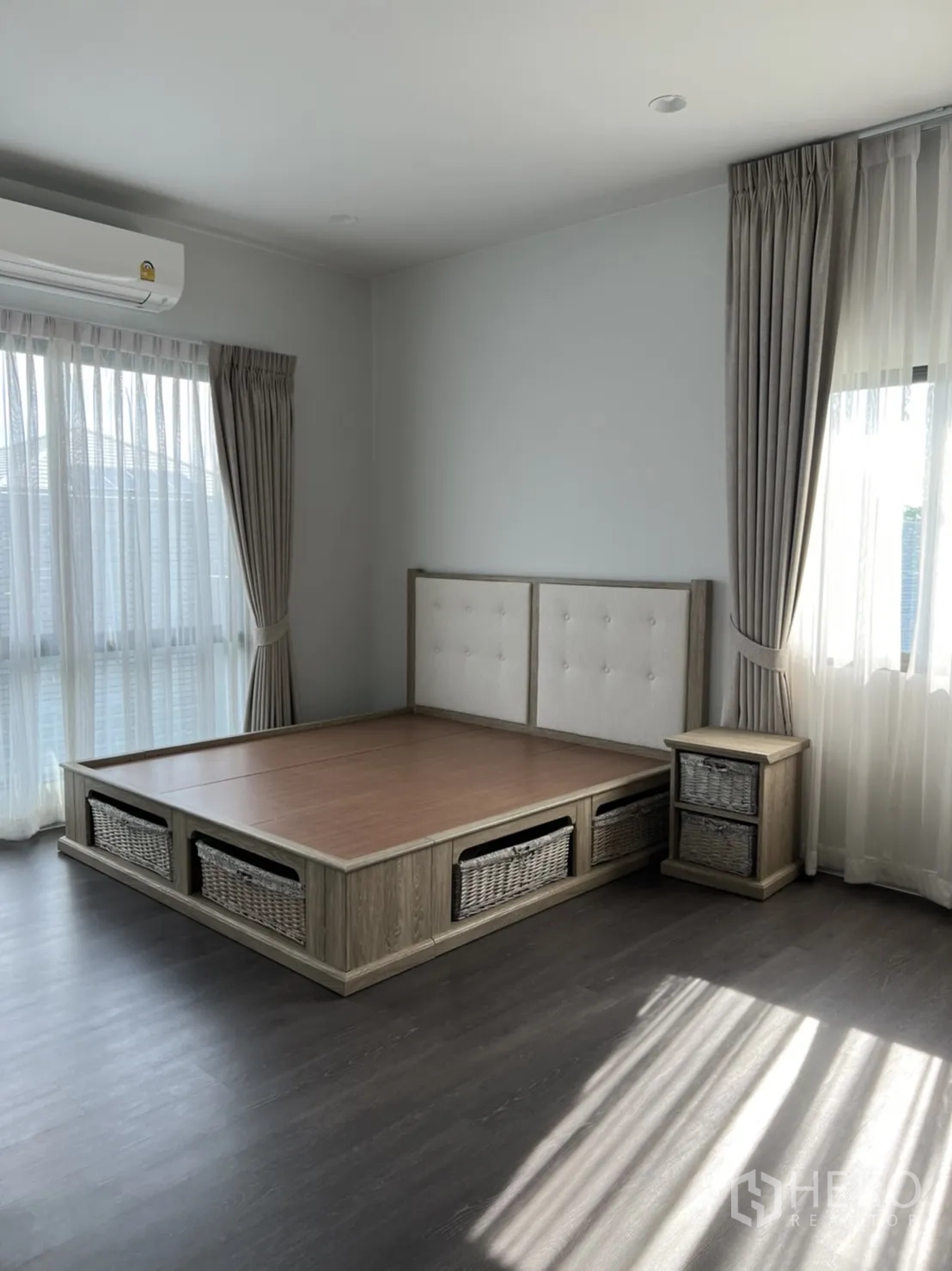 Detached House for rent in Bang Kapi, Bangkok - Bedroom with a platform bed frame, storage baskets, and a bedside table.