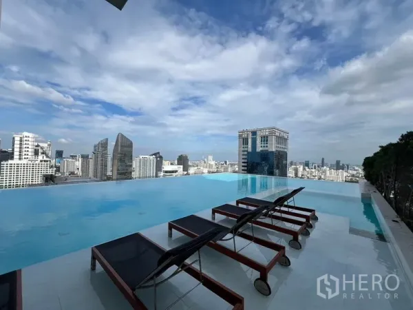 Condominium for rent in Watthana, Bangkok - Rooftop infinity pool with sun loungers and panoramic Bangkok skyline views in Asok.