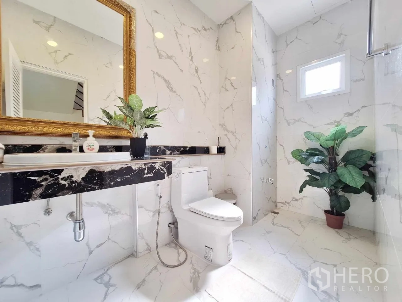 Home Office for sale in Bueng Kum, Bangkok - Marble-clad bathroom with vanity, toilet, and walk-in shower.