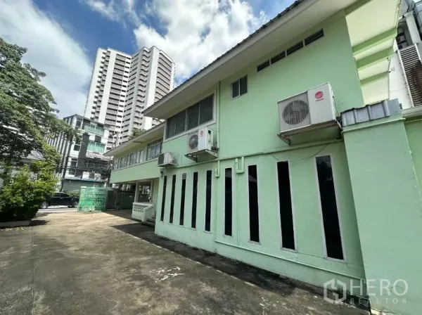 零售空间 出租在Watthana, Bangkok - 外立面一侧，竖窗与多台空调外机，背景为高楼。