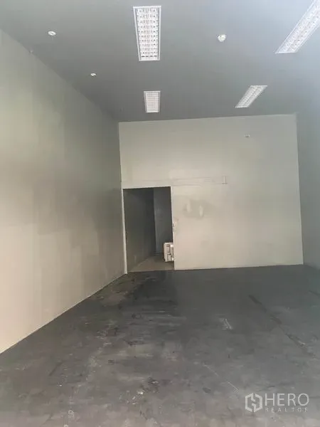 零售空间 出租在Khlong Toei, Bangkok - 开放式店铺内部，可见后方服务间与高墙面。