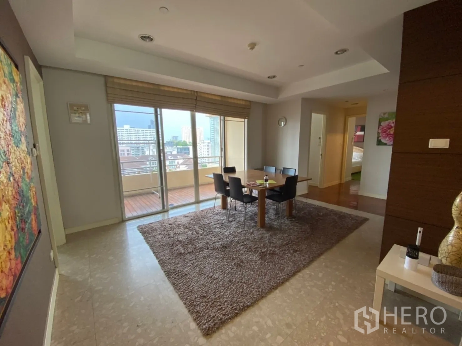 Condominium for rent in Watthana, Bangkok - Dining space beside balcony with city views through full-height glass doors.