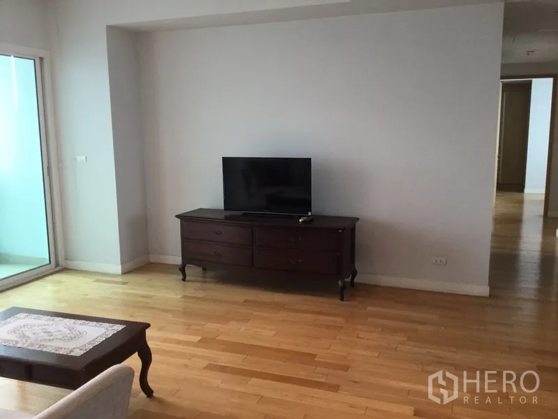 คอนโด ให้เช่าในKhlong Toei, Bangkok - มุมวางทีวีในห้องนั่งเล่นกว้าง พร้อมประตูกระจกบานเลื่อนออกไประเบียงและพื้นไม้สีอ่อน