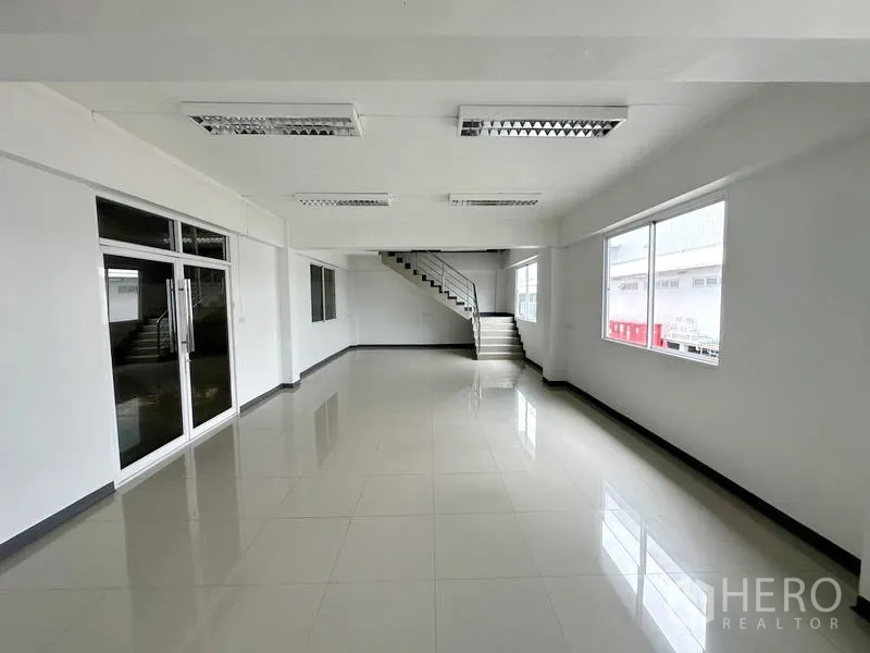 货栈 出租在Phra Nakhon Si Ayutthaya - 一层办公室，玻璃入口门与通往二层的楼梯。