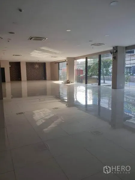 零售空间 出租在Bangkok - 开阔的零售室内空间，亮面地砖、吊顶空调与落地窗采光充足。