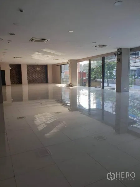 零售空间 出租在Bangkok - 开阔的零售室内空间，亮面地砖、吊顶空调与落地窗采光充足。