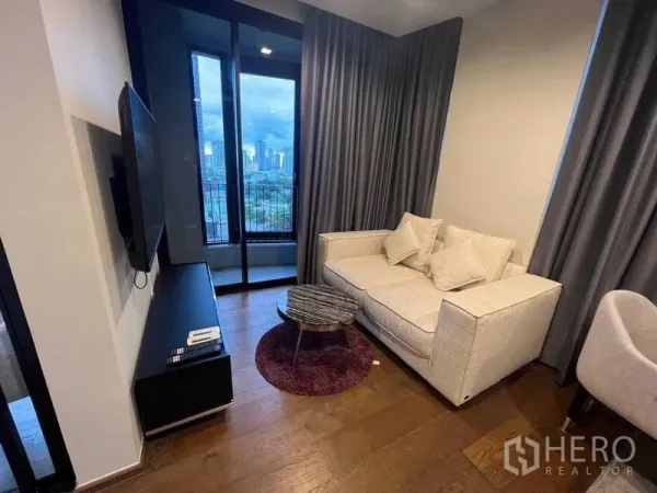 คอนโด ให้เช่าในKhlong Toei, Bangkok - มุมห้องนั่งเล่นอีกด้าน โซฟา ชั้นวางทีวี และระเบียงชมวิวเมือง