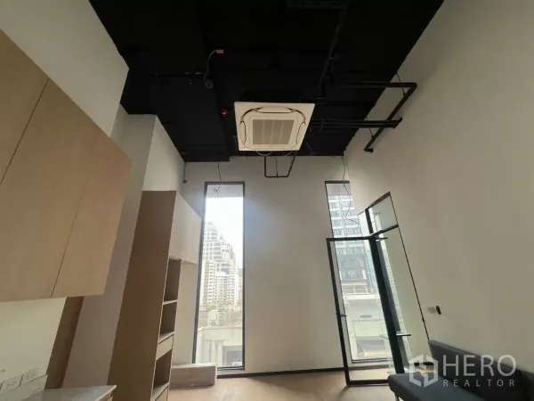 零售空间 出租 - 高挑层高的展厅，设有高窗、嵌入式空调、玻璃门与木质柜体。