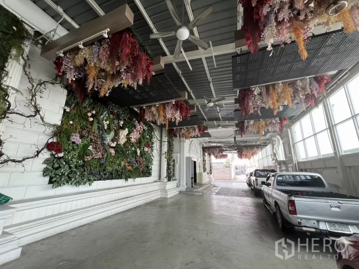 Retail Space for rent in Watthana, Bangkok - Covered drop-off and carpark with floral ceiling decor and pickup trucks.