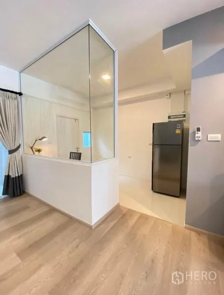 ทาวน์เฮาส์ ให้เช่าในBang Phli, Samut Prakan - โถงทางเดินมีฉากกั้นกระจก มองเห็นโต๊ะทำงานและทางไปครัวที่มีตู้เย็น