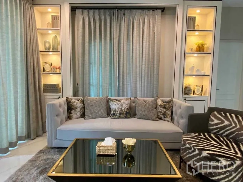 独立式住宅 出租在Bang Khen, Bangkok - 沙发区特写，左右展示柜带柔和灯光。