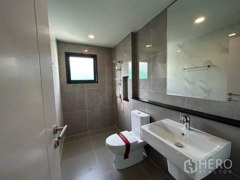 Detached House for rent - Contemporary tiled bathroom with window, vanity, and walk-in shower.