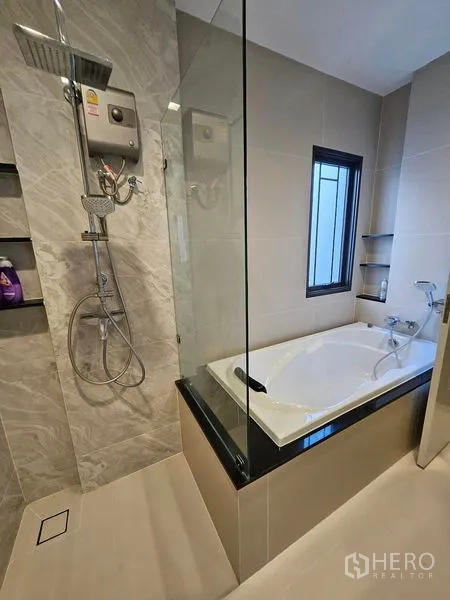 Detached House for sale in Mueang Pathum Thani, Pathum Thani - Modern bathroom with glass shower and separate soaking bathtub.