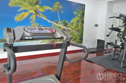 อพาร์ทเมนท์ ให้เช่าในKhlong Toei, Bangkok - ห้องฟิตเนสพร้อมลู่วิ่ง เครื่องยกน้ำหนัก และภาพจิตรกรรมแนวทะเลบนผนัง