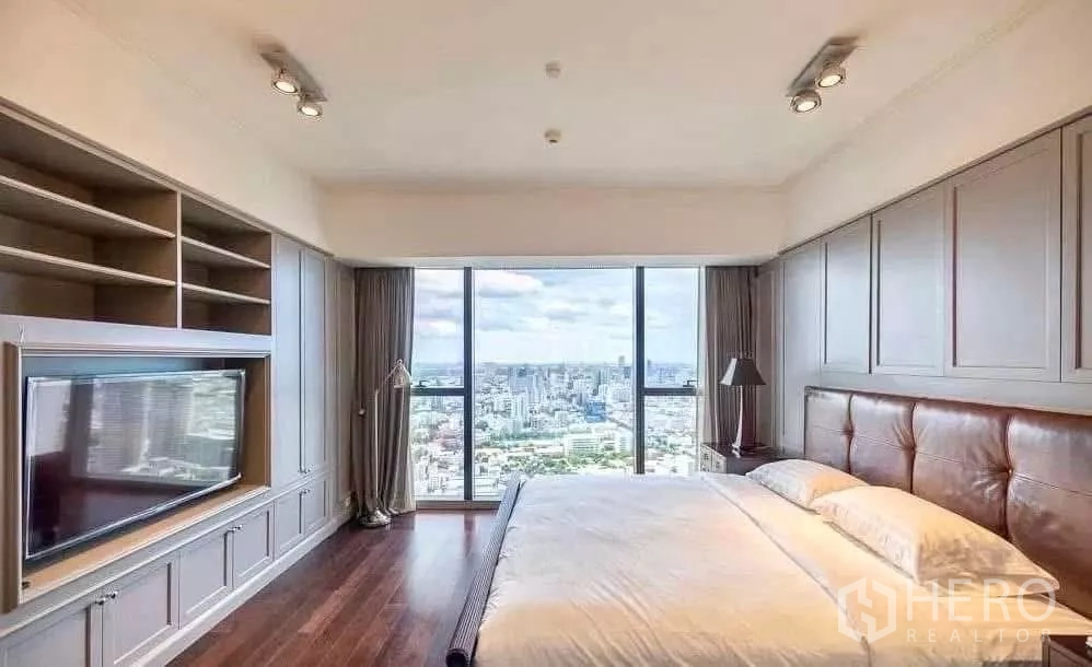 Condominium for rent in Sathon, Bangkok - Primary bedroom with built-in media wall, leather headboard and panoramic skyline.