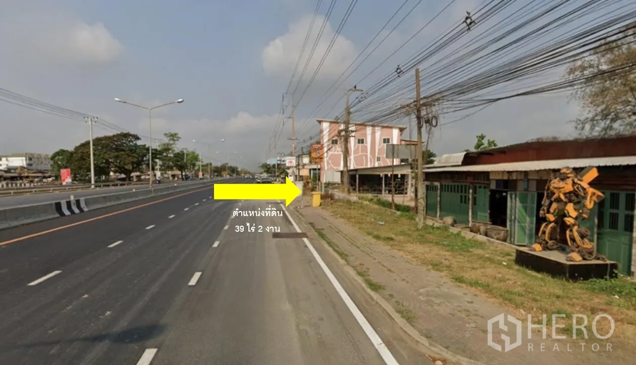 ที่ดิน ขายในThanyaburi, Pathum Thani - ภาพถนนรังสิต–นครนายก 6 เลน ระดับสายตา มีอาคารพาณิชย์และสายไฟ ใกล้หน้าที่ดินกว้างราว 35 เมตร