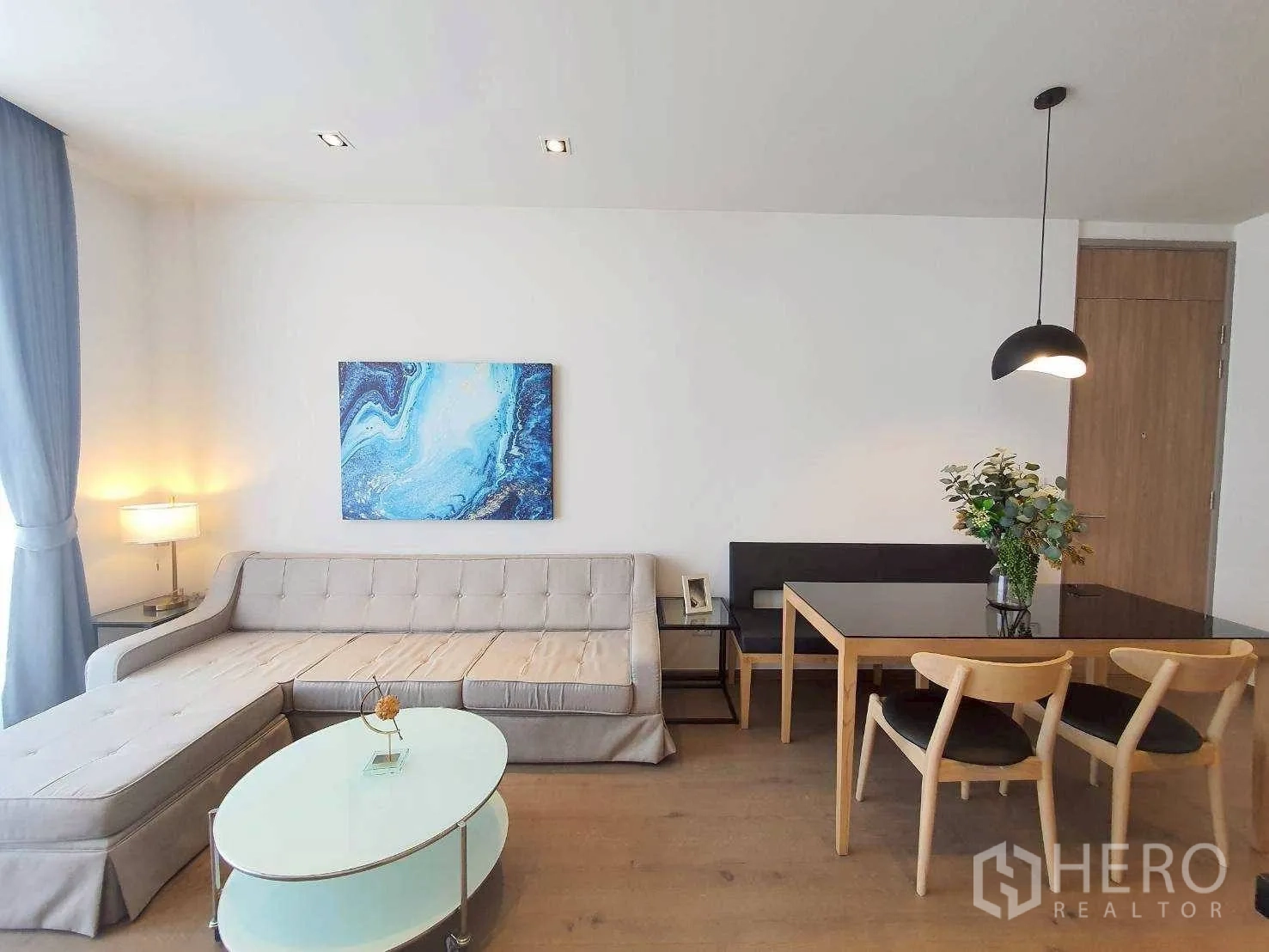 คอนโด for rent in Khlong Toei, Bangkok - พื้นที่นั่งเล่นและรับประทานอาหารแบบเปิดโล่ง โซฟา L‑shape และชุดโต๊ะกินข้าว