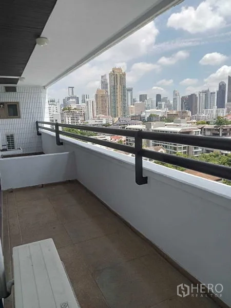Condominium for rent in Watthana, Bangkok - Long balcony with skyline view over Sukhumvit under a blue sky.