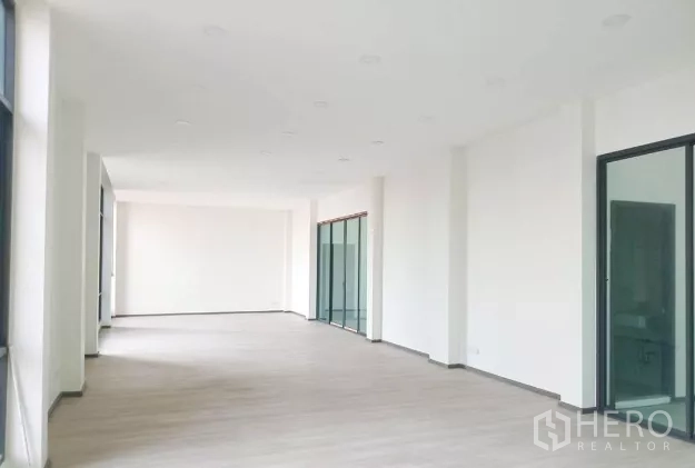 คลังสินค้า ให้เช่าในMueang Samut Sakhon, Samut Sakhon - พื้นที่ออฟฟิศชั้นบนแบบเปิดโล่ง ผนังสีขาว พื้นลามิเนต และประตูกระจกบานเลื่อนหลายบาน