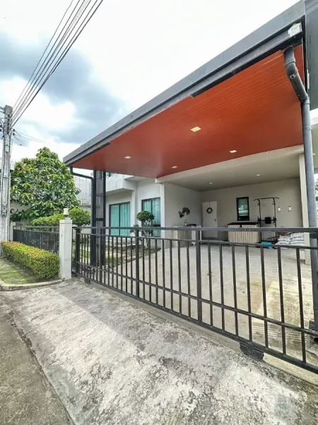 Detached House for rent in Saphan Sung, Bangkok - Street view of a modern two-storey corner house with sliding gate and large covered carport.