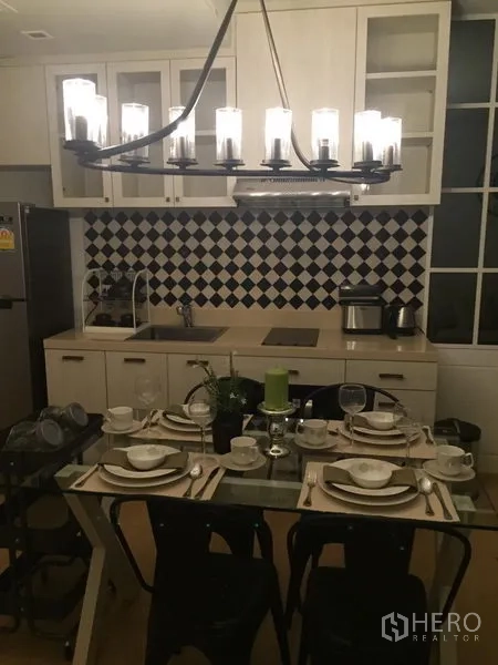 คอนโด ให้เช่าในPhaya Thai, Bangkok - ครัวบิวท์อินตู้สีขาว ผนังกระเบื้องลายขาวดำ พร้อมชุดรับประทานอาหารและโคมไฟเด่น