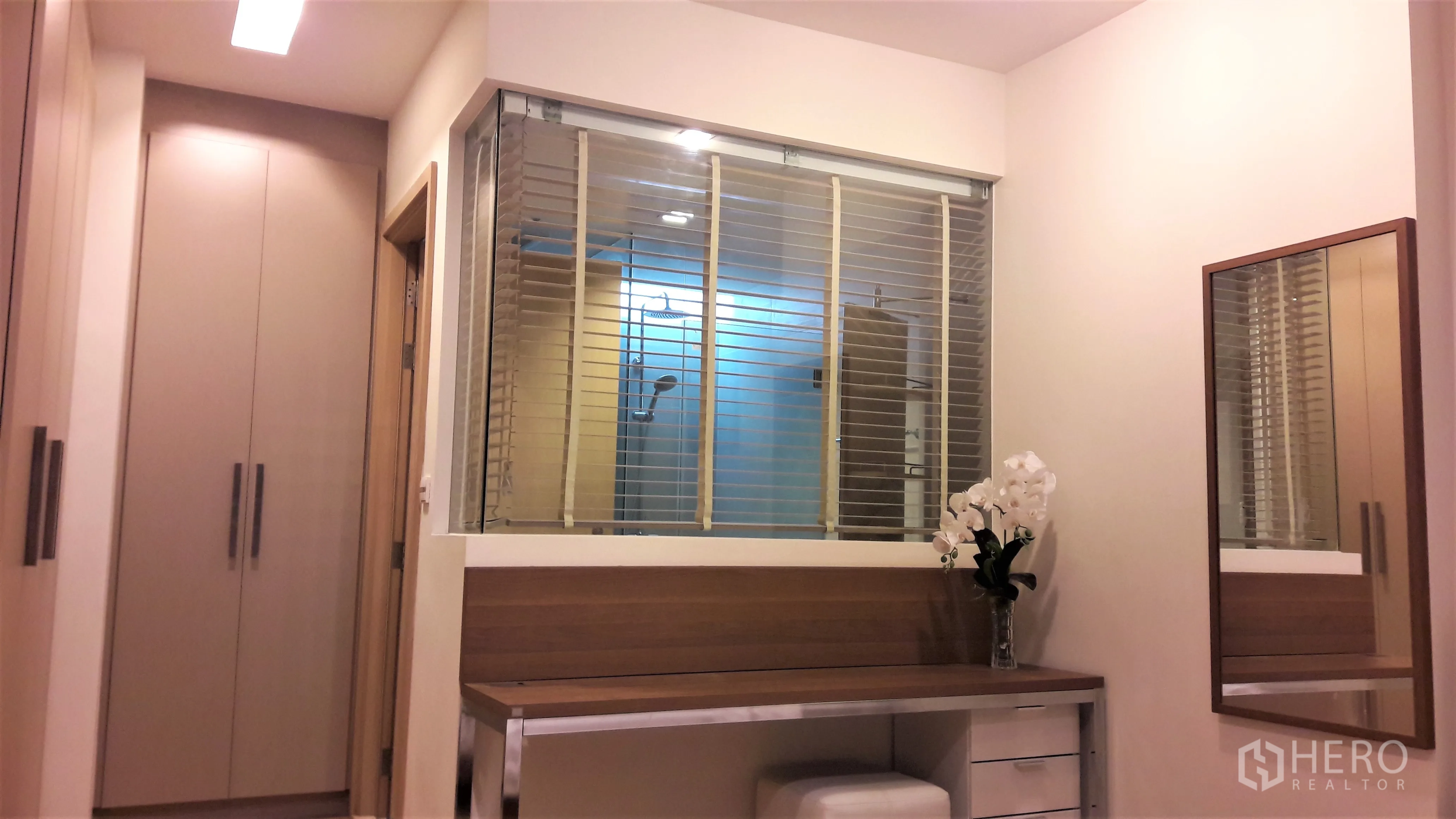 คอนโด ให้เช่าในKhlong Toei, Bangkok - โซนแต่งตัวตู้บิวท์อิน โต๊ะเครื่องแป้งไม้ และผนังกระจกพร้อมมู่ลี่มองเห็นห้องอาบน้ำ