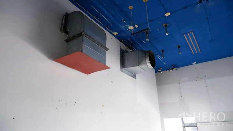 零售空间 出租在Watthana, Bangkok - 高处蓝色天花上的外露通风风管特写。