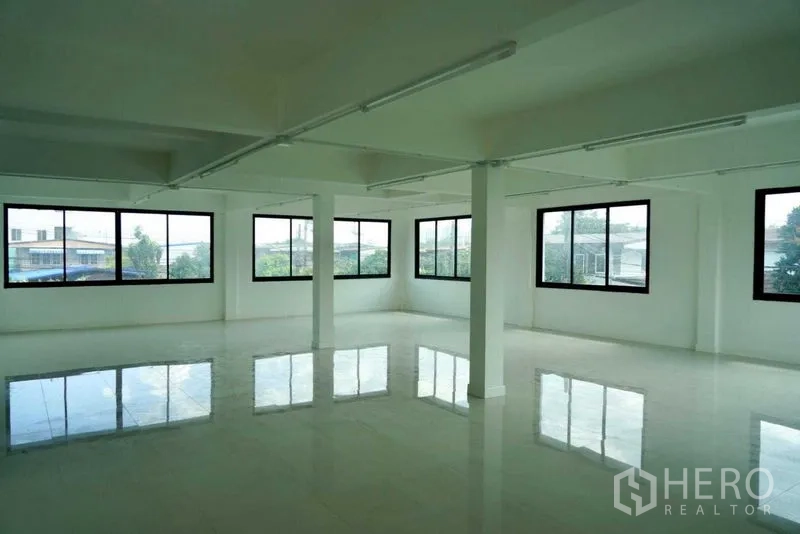 Office Space for sale in Khan Na Yao, Bangkok - Expansive upper-floor office with panoramic windows and glossy white tiles.