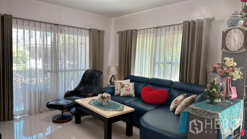 Detached House for rent in Bang Phli, Samut Prakan - Corner living area with large windows, blue L-shaped sofa, and decor.