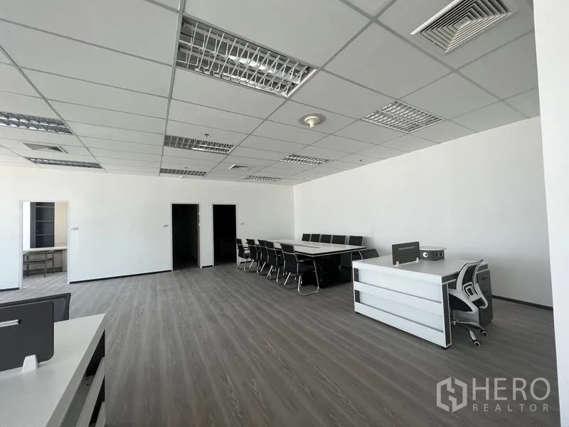 Office Space for rent in Huai Khwang, Bangkok - Open office corner with a boardroom table, reception desk and doors to private rooms.