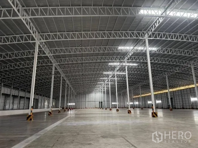 Factory for rent in Si Racha, Chon Buri - High roof truss structure with skylights and LED lights spanning the warehouse.