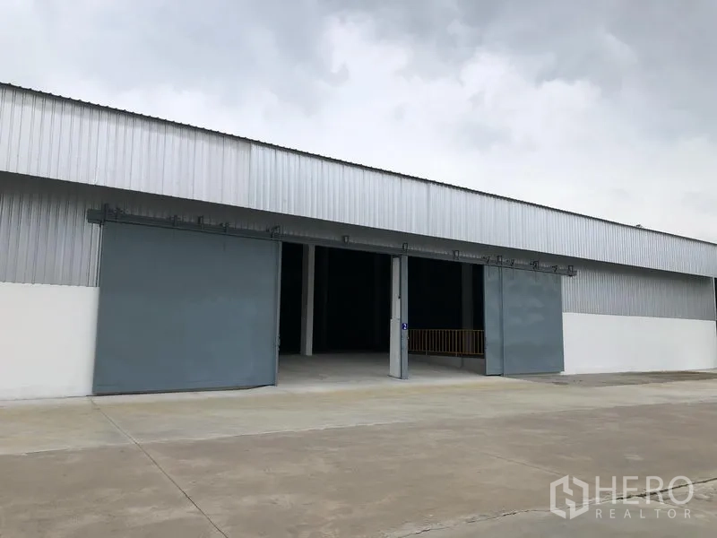 Warehouse for rent in Nonthaburi - Angled exterior of the warehouse showing open loading bays and a smooth loading apron.