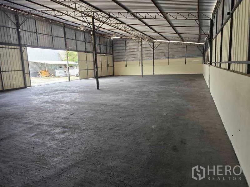 Warehouse for rent in Khlong Sam Wa, Bangkok - Open steel-frame warehouse interior with a high roof and concrete floor.