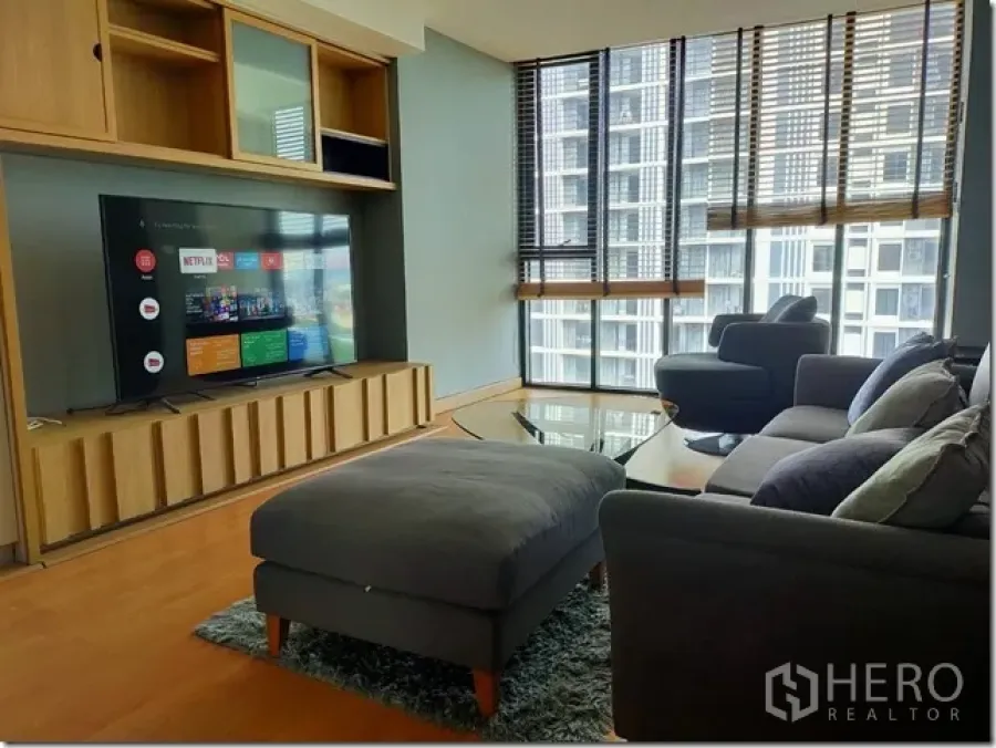 公寓 出租在Watthana, Bangkok - The Alcove 10 明亮客厅，灰色沙发、电视柜，落地窗俯瞰城市景观