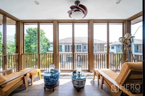 บ้าน ขายในPrawet, Bangkok - ห้องซันรูมกระจกเต็มบาน รับแสงธรรมชาติ มีเก้าอี้พักผ่อนและโคมไฟโมเดิร์น.