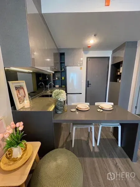 คอนโด ให้เช่า - ครัวโมเดิร์นขนาดกะทัดรัด ตู้เก็บของเงา ตู้เย็น ซิงก์ และเคาน์เตอร์ทานอาหาร 2 ที่