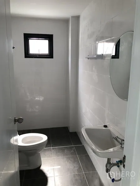 工厂 出租在Bang Yai, Nonthaburi - 简洁的卫浴，带坐便器、洗手盆、镜子与通风窗。